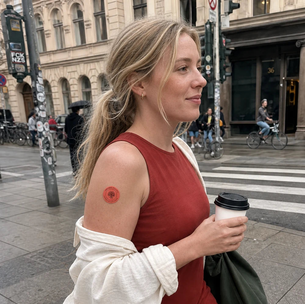 Eine Frau geht durch die Stadt und trägt ein Elanessa Pflaster am Oberarm